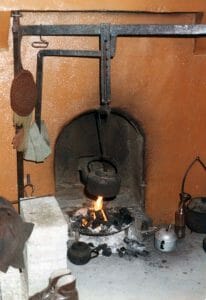 The old hearth fire with its crane and crook and the kettle boiling for a cup of tea